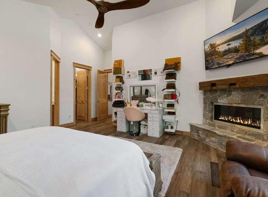 Step into luxury with this stunning bedroom featuring a cozy fireplace and a stylish vanity area.