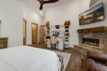 Step into luxury with this stunning bedroom featuring a cozy fireplace and a stylish vanity area.