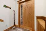 Step into this inviting entryway, showcasing a stunning wooden door with a modern glass panel.