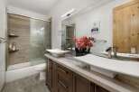 This stunning bathroom features a modern design with a sleek vanity and two stylish sinks.