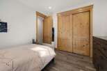 Discover the charm of this inviting bedroom, featuring beautiful wooden doors and a cozy bed.