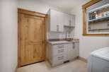 This stunning laundry room boasts a modern design with sleek cabinetry and a convenient sink area.