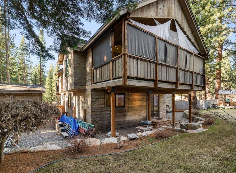 Nestled in a serene wooded setting, this stunning property boasts a unique architectural design with a raised deck and screened-in porch.
