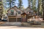 This stunning mountain home boasts a rustic charm with its wood and stone exterior, offering a warm and inviting atmosphere.