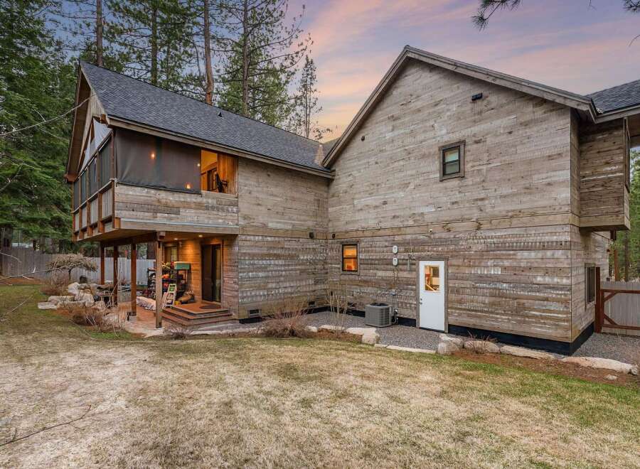 This stunning property boasts a unique architectural design with beautiful wooden siding, creating a warm and inviting atmosphere.