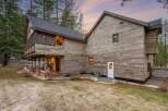 This stunning property boasts a unique architectural design with beautiful wooden siding, creating a warm and inviting atmosphere.