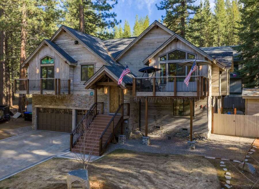 This stunning property boasts a rustic exterior with a blend of wood and stone, creating a warm and inviting atmosphere.