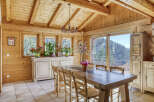 Step into this stunning wooden cabin, featuring a spacious dining area perfect for gatherings.