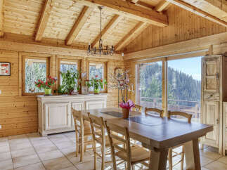 Step into this stunning wooden cabin, featuring a spacious dining area perfect for gatherings.