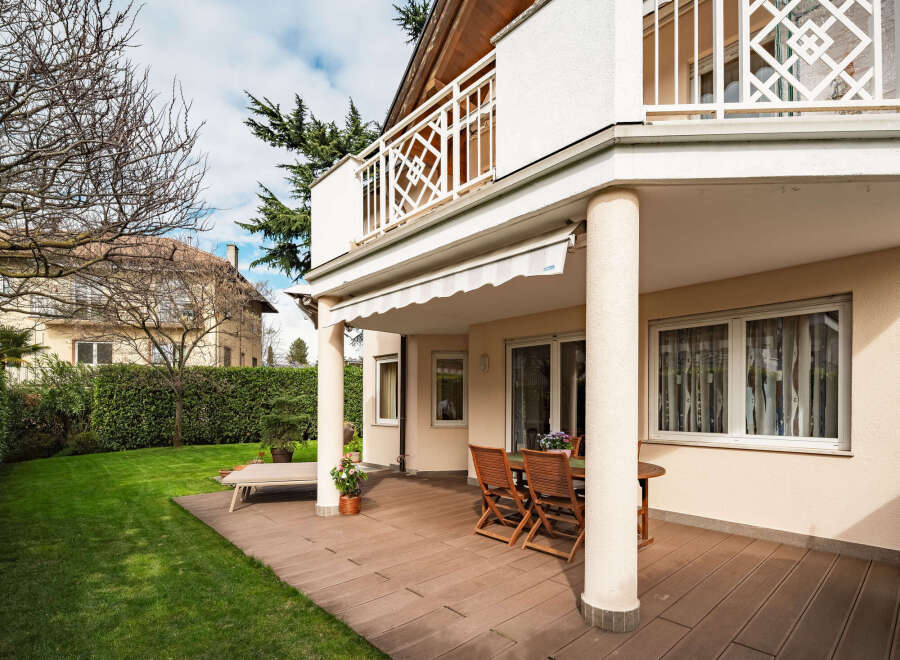 Enjoy outdoor living at its finest with this stunning property featuring a spacious patio and lush green lawn.