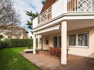 Enjoy outdoor living at its finest with this stunning property featuring a spacious patio and lush green lawn.