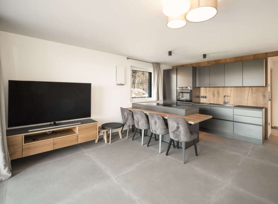 This modern living space boasts a sleek kitchen with ample storage and a stylish island, perfect for entertaining.