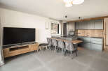 This modern living space boasts a sleek kitchen with ample storage and a stylish island, perfect for entertaining.
