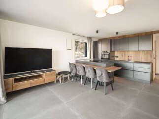 This modern living space boasts a sleek kitchen with ample storage and a stylish island, perfect for entertaining.
