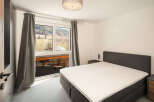 This stunning bedroom boasts a modern design with a comfortable bed and a serene ambiance.