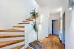 This stunning property features a modern staircase with wooden steps and white risers, creating a sleek and inviting entryway.