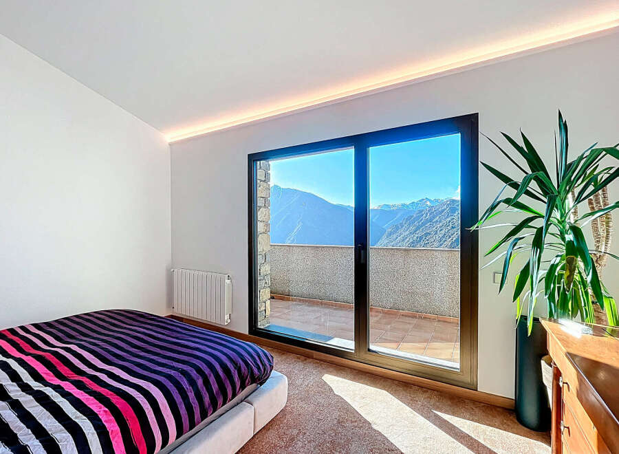 Experience breathtaking mountain views from this stunning bedroom.