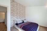 This stylish bedroom features a modern design with a unique wallpaper accent wall.