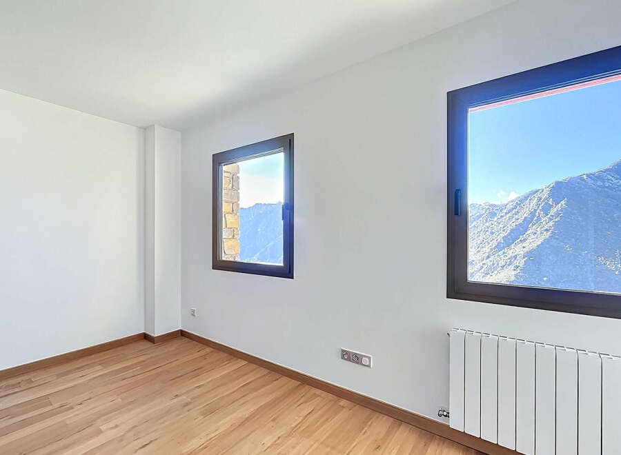 This stunning property boasts breathtaking mountain views framed by large windows, creating a bright and airy atmosphere.