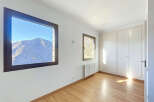 This bright and airy room features stunning mountain views through large windows, offering a serene and picturesque setting.