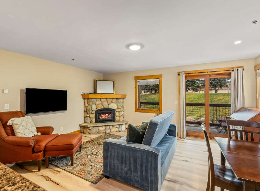 This cozy living space features a stone fireplace, perfect for those chilly evenings.