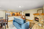 Cozy up in this charming living space, complete with a stone fireplace and a comfortable sofa.
