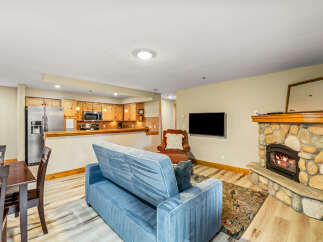 Cozy up in this charming living space, complete with a stone fireplace and a comfortable sofa.
