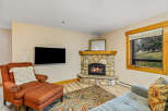 This cozy living room features a stunning stone fireplace, perfect for those chilly evenings.
