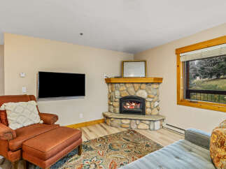 This cozy living room features a stunning stone fireplace, perfect for those chilly evenings.