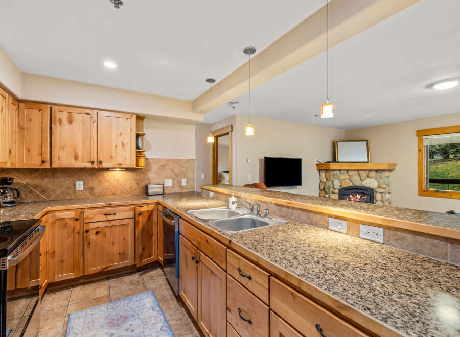 This stunning kitchen boasts beautiful wooden cabinetry and granite countertops, creating a warm and inviting atmosphere.