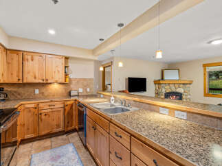 This stunning kitchen boasts beautiful wooden cabinetry and granite countertops, creating a warm and inviting atmosphere.