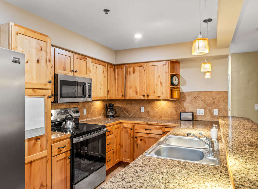 This stunning kitchen boasts beautiful wooden cabinetry and a modern stainless steel appliance package.