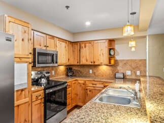 This stunning kitchen boasts beautiful wooden cabinetry and a modern stainless steel appliance package.