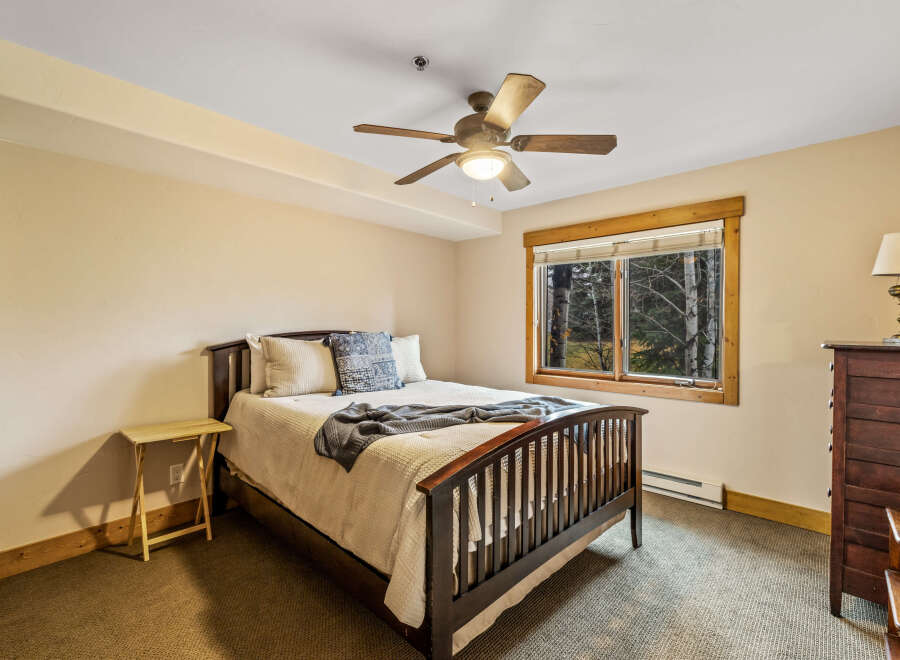 This cozy bedroom features a comfortable bed with soft bedding and a stylish throw blanket.