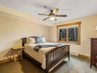 This cozy bedroom features a comfortable bed with soft bedding and a stylish throw blanket.