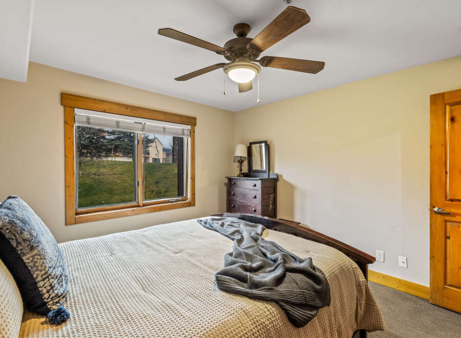 This cozy bedroom features a comfortable bed with a textured blanket and decorative pillows, perfect for a relaxing retreat.