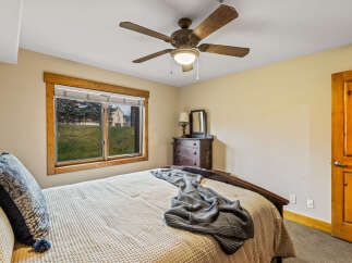 This cozy bedroom features a comfortable bed with a textured blanket and decorative pillows, perfect for a relaxing retreat.