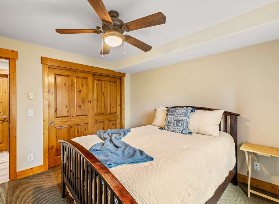 This cozy bedroom features a warm, inviting atmosphere with its wooden accents and neutral color palette.