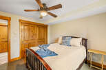 This cozy bedroom features a warm, inviting atmosphere with its wooden accents and neutral color palette.