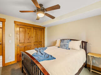 This cozy bedroom features a warm, inviting atmosphere with its wooden accents and neutral color palette.