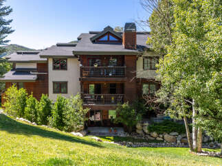 Experience mountain living in this stunning multi-level residence, featuring rich wood siding and expansive balconies perfect for enjoying the serene surroundings.