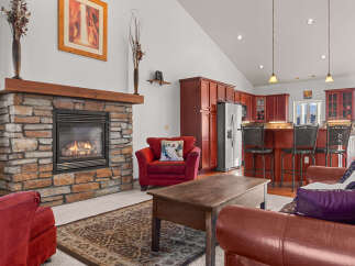 This stunning property boasts a cozy living room with a stone fireplace, perfect for relaxing evenings.