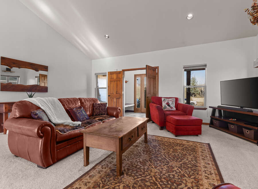 Step into luxury with this stunning living room, featuring a cozy leather sofa and a stylish red armchair.