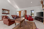 Step into luxury with this stunning living room, featuring a cozy leather sofa and a stylish red armchair.