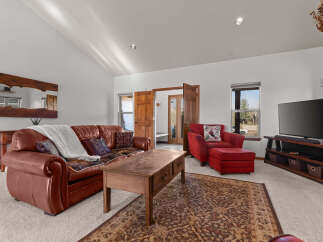 Step into luxury with this stunning living room, featuring a cozy leather sofa and a stylish red armchair.