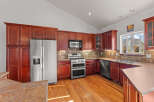 This stunning kitchen boasts rich, dark wood cabinetry and gleaming stainless steel appliances, creating a warm and inviting atmosphere.