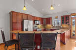 This stunning kitchen boasts rich wood cabinetry, stainless steel appliances, and a stylish breakfast bar.