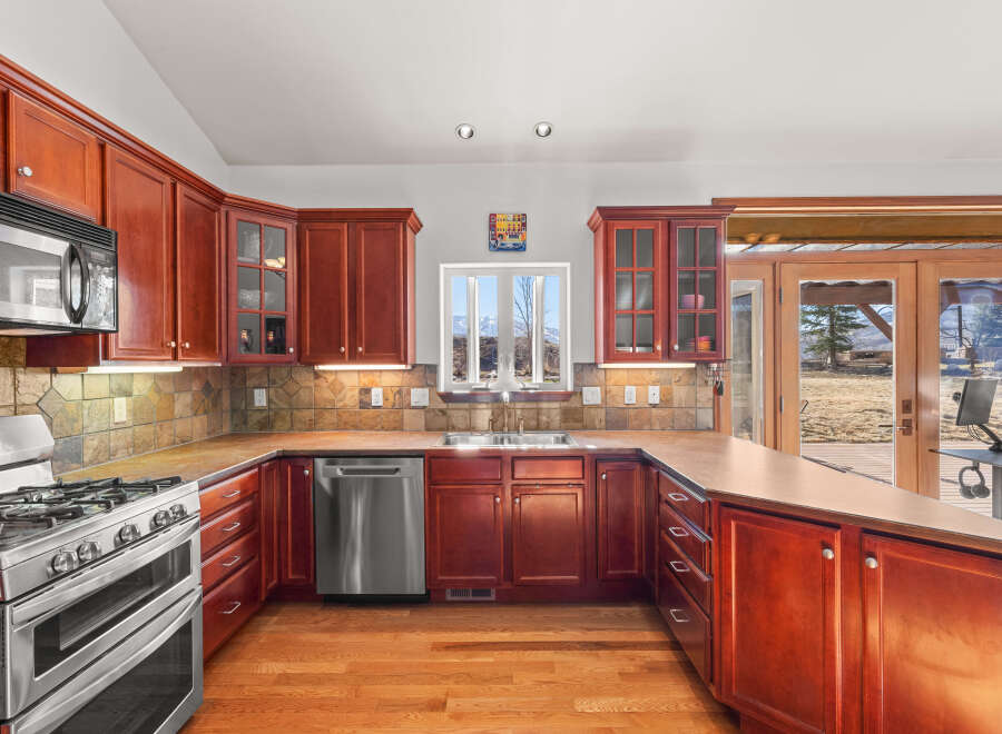 This stunning kitchen boasts rich, dark wood cabinetry and a sleek stainless steel appliance package.