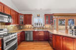 This stunning kitchen boasts rich, dark wood cabinetry and a sleek stainless steel appliance package.
