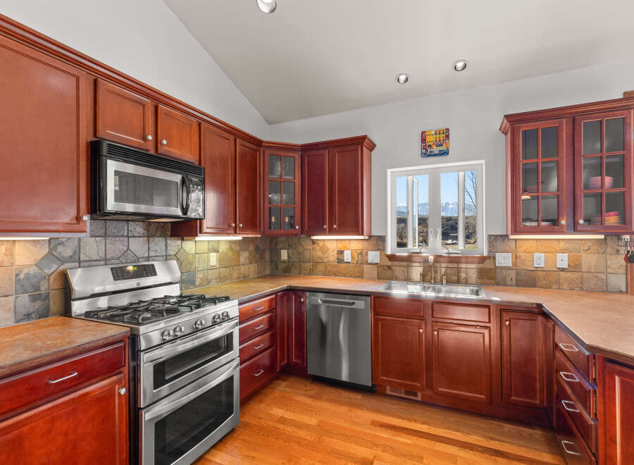 This stunning kitchen boasts rich, wooden cabinetry and sleek stainless steel appliances, creating a warm and inviting atmosphere.